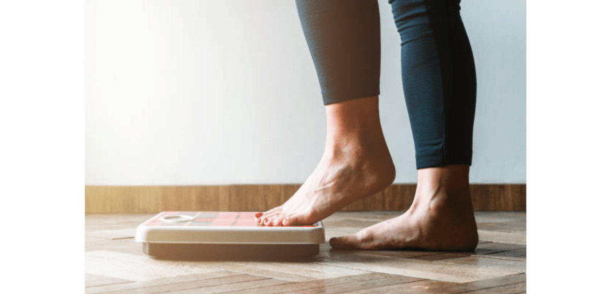 A woman who is under a weight loss program using GLP-1 medication weighing herself on a scale | Lafayette, Louisiana