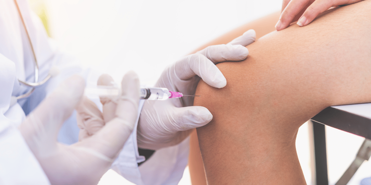 Doctor giving injection in knee