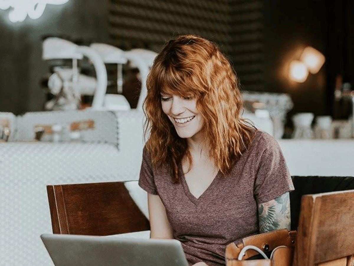 Energy Boost - Happy female sitting down working on her computer