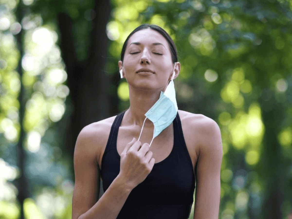 Immunity - Female taking off her medical mask getting fresh air