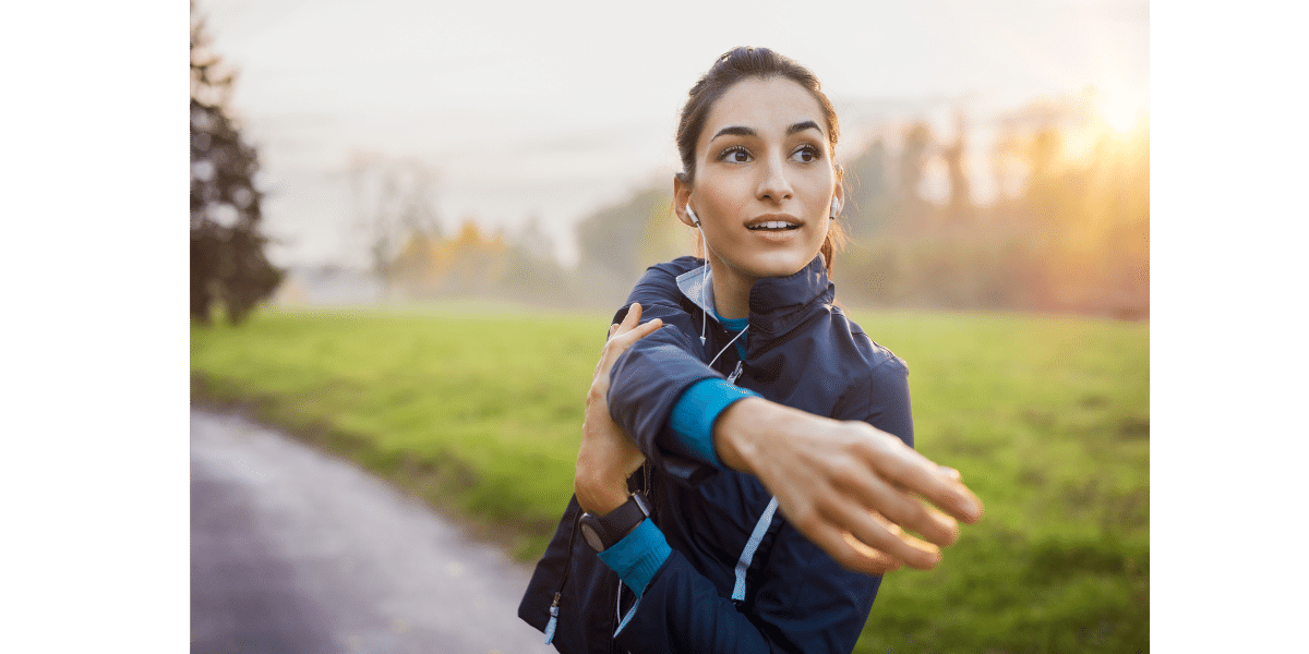 Middle aged female stretching and warming up before a run outside