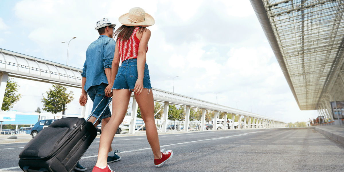 Couple with suitcase walking in airport terminal.