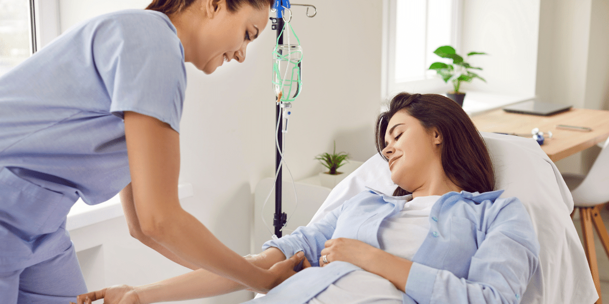 Female nurse preparing patient's arm for an IV