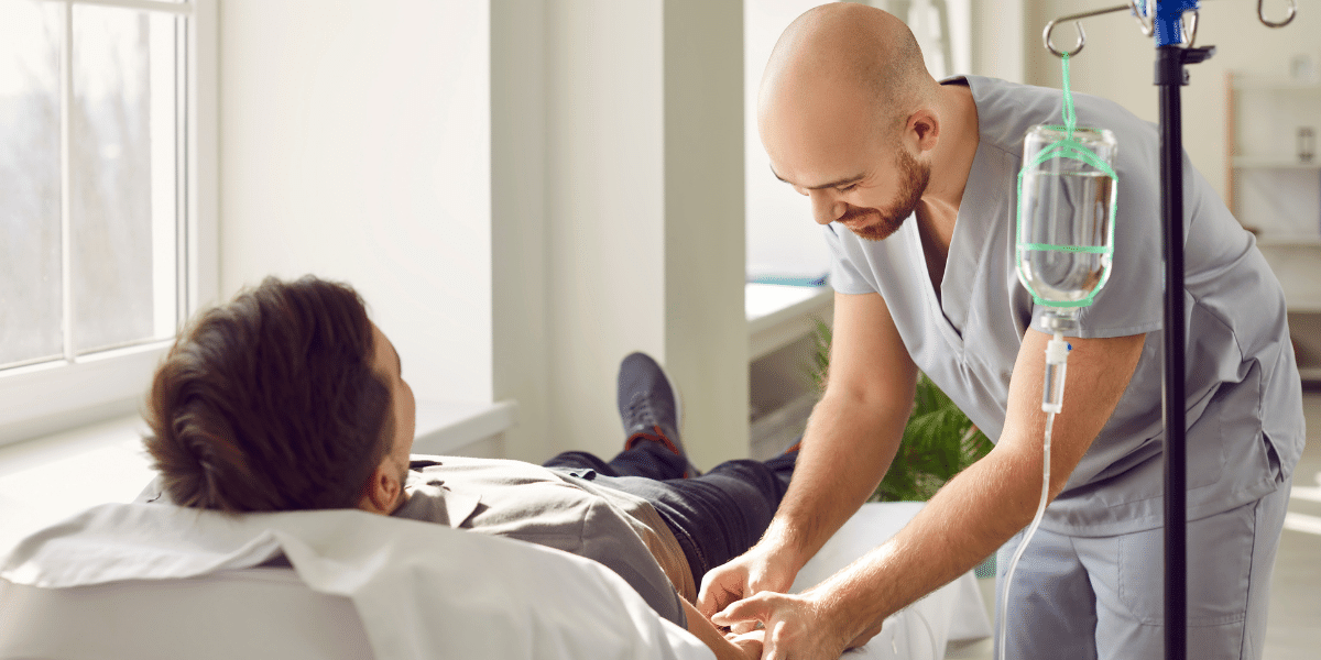 Male nurse administering IV drip