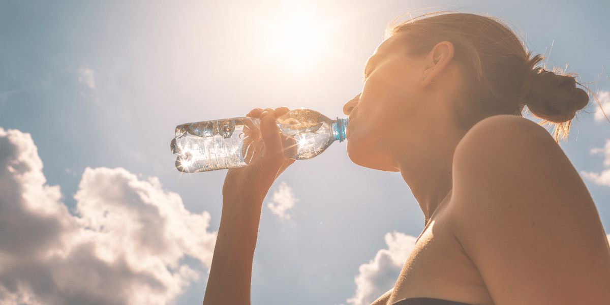 Woman drinking water in the hot sun